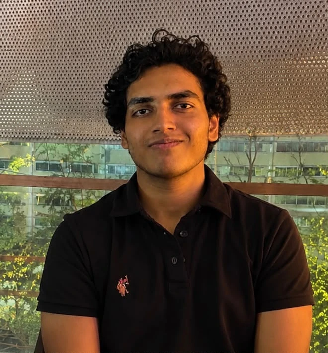Anirva Manchikatla smiling, in a black polo shirt